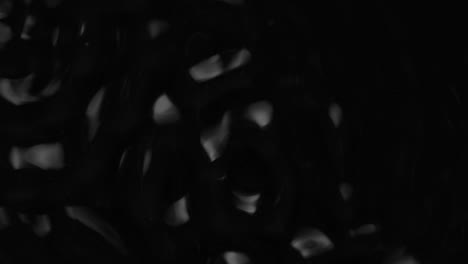 splashes and drops on the surface of the liquid. abstract black background water vibration. 4k slow motion 100 fps, prores 422, 10 bit