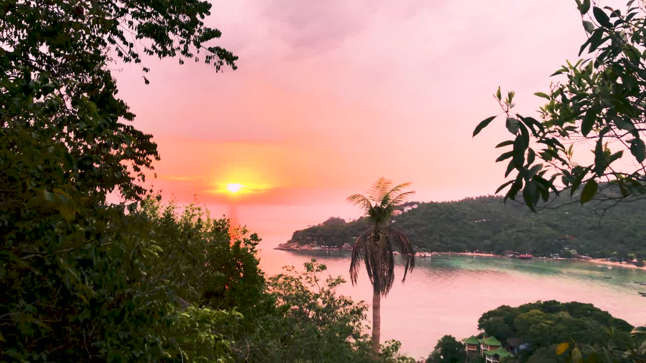 puesta de sol colorida que brilla sobre la playa, el océano y el bosque junto a las montañas desde el mirador john-suwan en ko tao, tailandia durante el verano