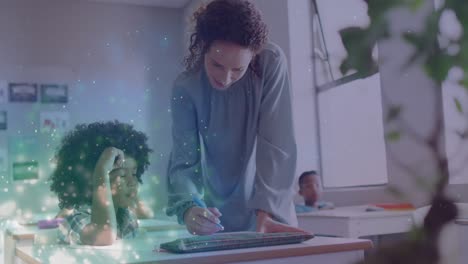 animation of light particles over happy diverse female teacher helping schoolboy at desk in class