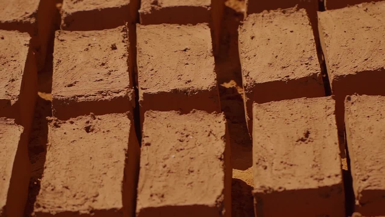 Rows of freshly made adobe bricks are drying under the sun in Chapada dos Veadeiros, Brazil, showcasing a sustainable and traditional building technique
