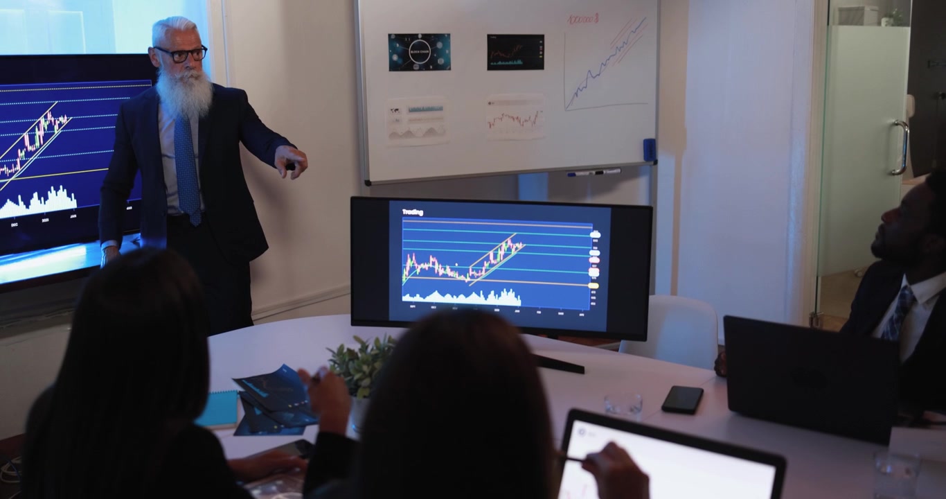 Senior Financial Advisor Presenting Stock Market Trends to Team