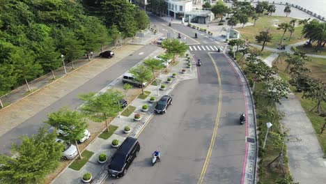 scooters and cars driving next to seaside recreational area