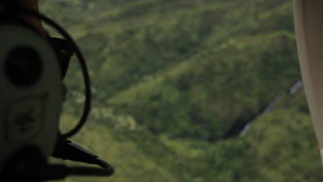 man wearing headset looks over hawaii landscape from helicopter