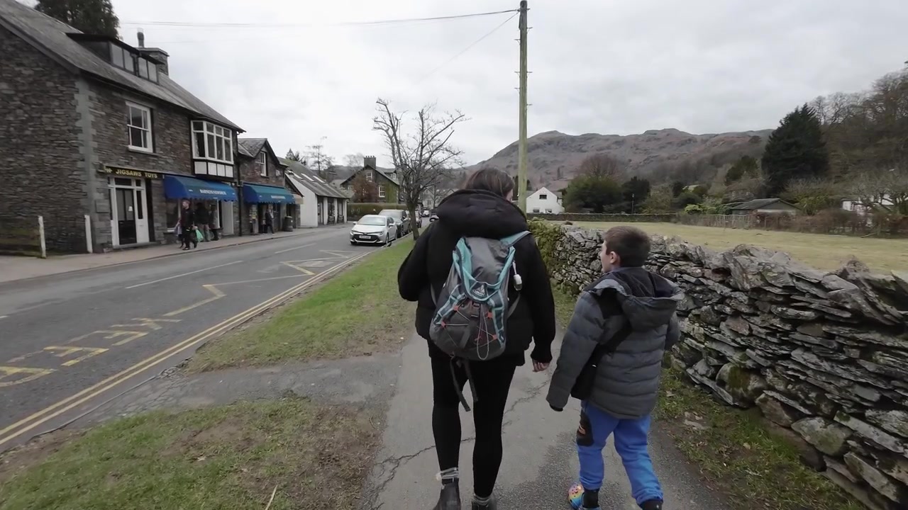 Redaktionelt videomateriale fra den cumbrianske landsby Grasmere i det engelske Lake District. Viser mor og søn, der går i byen