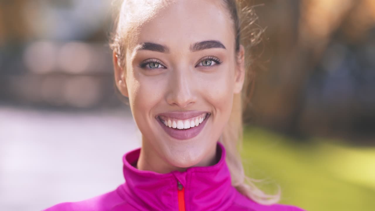 mujer sonriente con ropa deportiva rosa