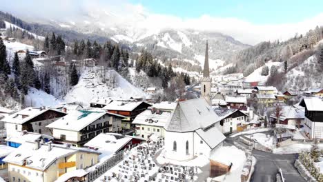 droneview of a small snowy winter village in the austrian alps