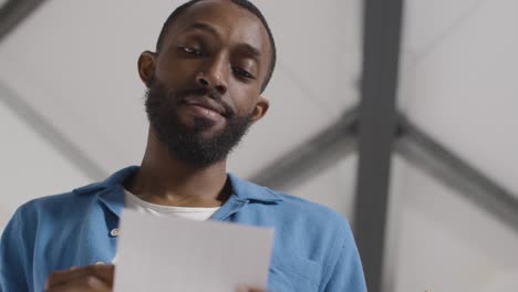 man holding ballot paper in political election deciding how to cast his vote