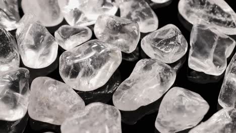 clear quartz stones displayed on a black surface with bright lighting, highlighting their transparency and texture