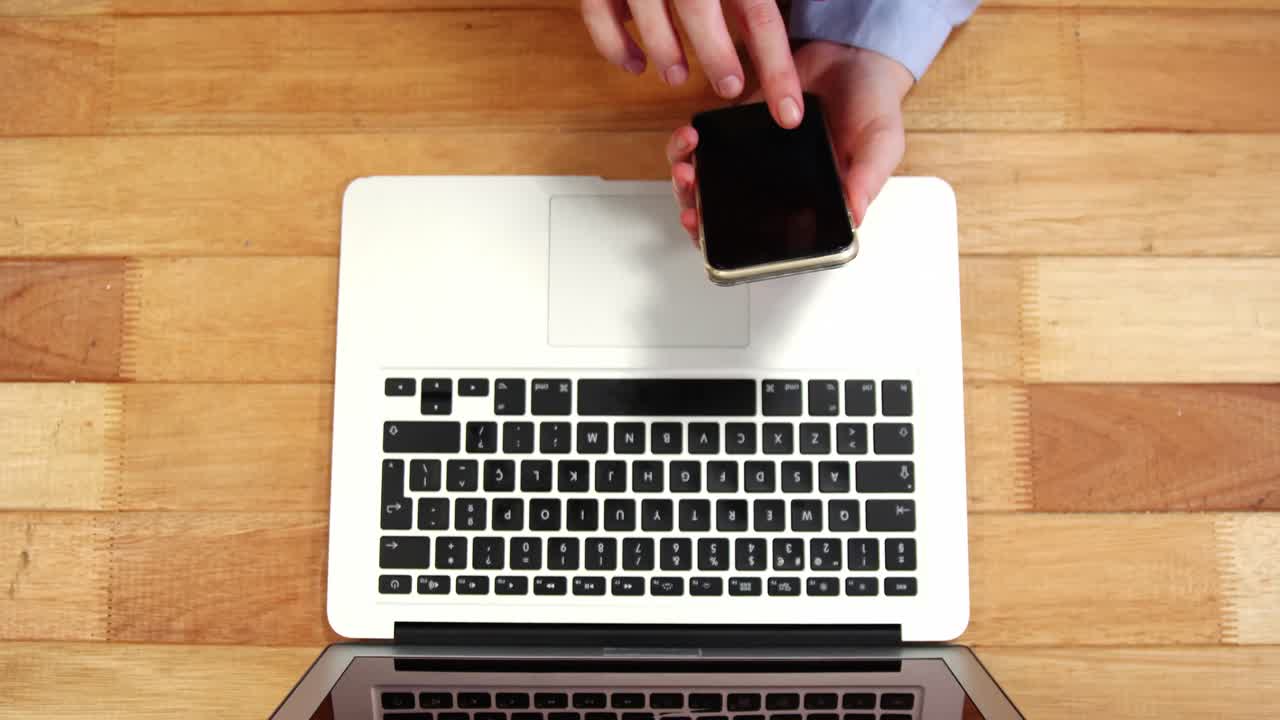 책상 에서 노트북 에서 일 하는 동안 휴대 전화 를 사용하는 여자