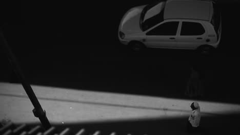 a lone person walks through a dramatic shadowed path in black and white contrast lighting, bangalore india