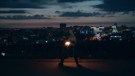 young blond male does tricks with fire male kneels while breathing fire making fireball