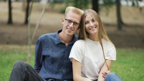 portrait of a young beautiful couple on a picnic. the guy hugs the girl. happiness, leisure