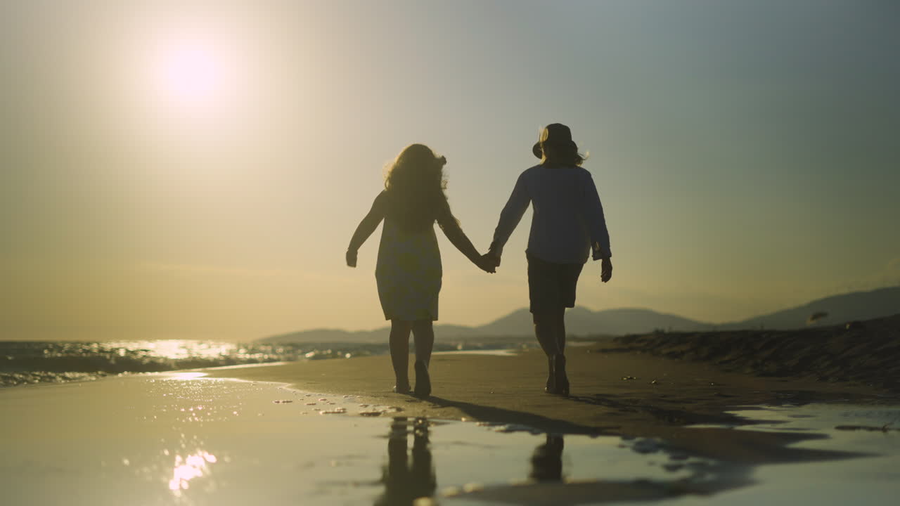 해가 지는 해변에서 손잡고 는 두 소녀