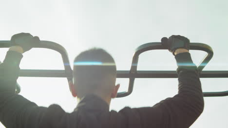 man doing pull ups on workout playground