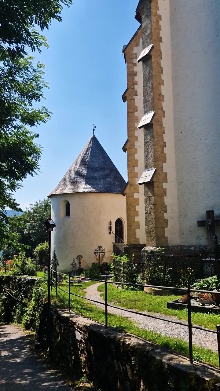 Giardini e cimitero intorno alla Chiesa Cattolica nel villaggio di Maria Worth, Austria, vista verticale