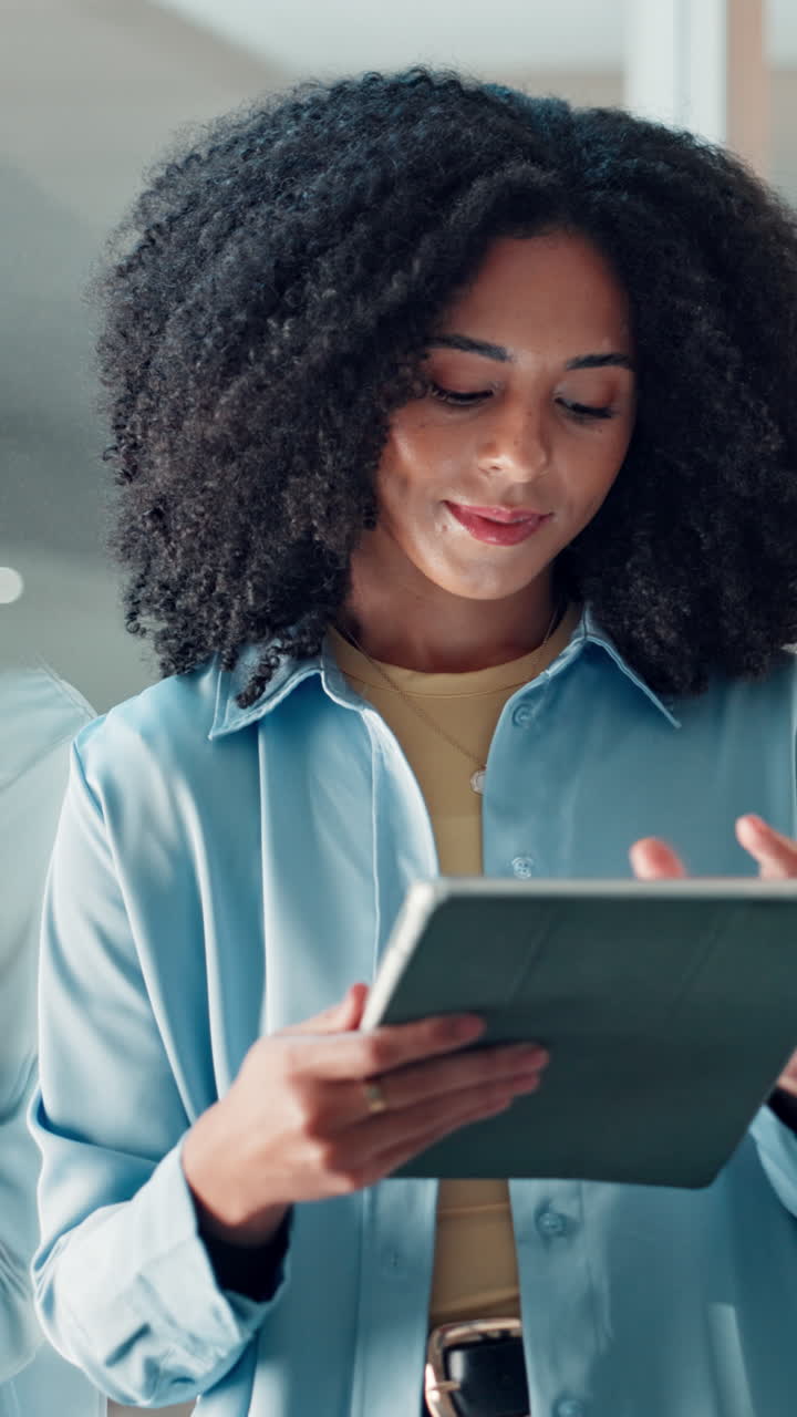 Young Black Woman Smiling While Using a Digital Tablet