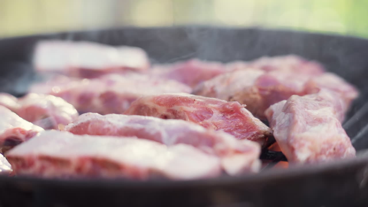 deslice a cámara lenta más allá de la parrilla de carne en una parrilla de barbacoa ardiente y ahumada