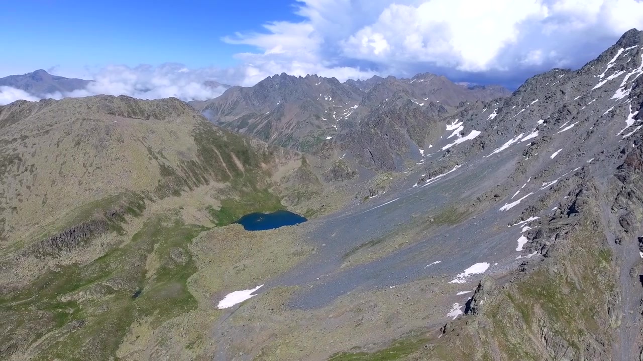 Vista aérea de una cordillera alpina con un lago glacial