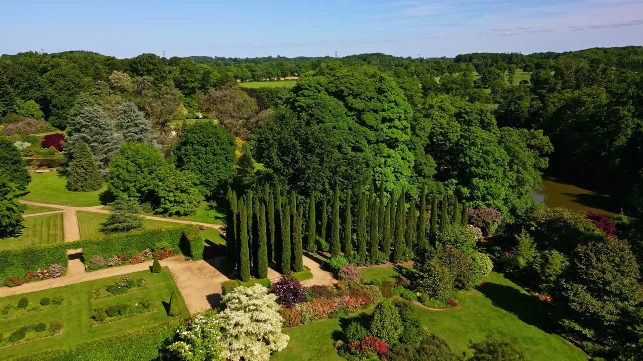 Parc de Haute Bretagne botanical garden on sunny day in France. Aerial drone forward