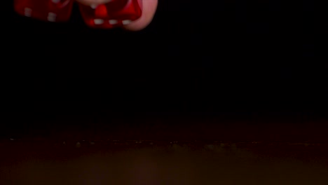 los dados rojos rodando en una superficie oscura