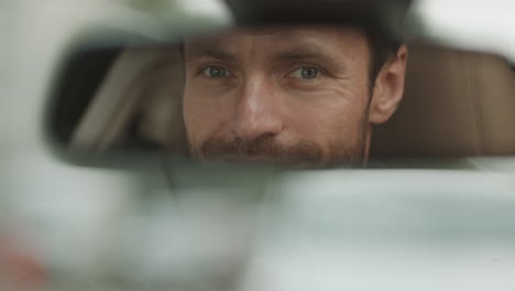 man looking in rear view mirror