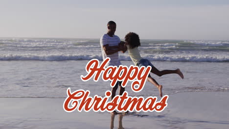 animation of christmas greetings text over african american man with daughter on beach