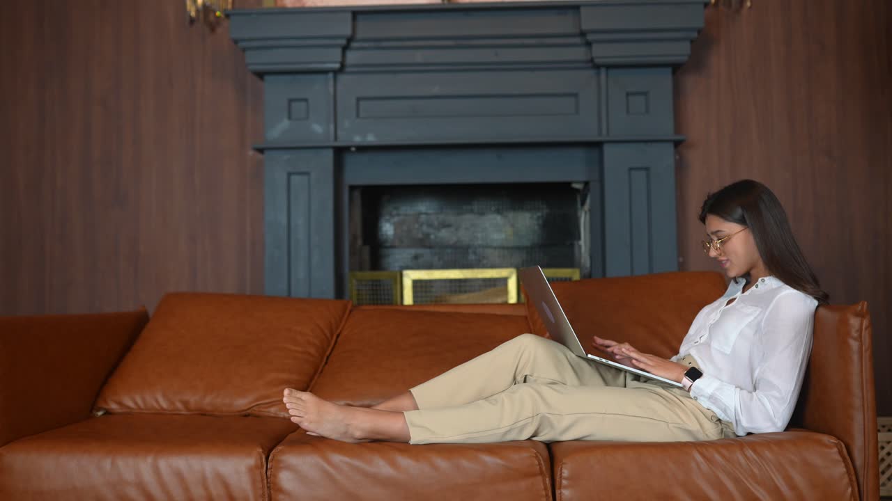 mujer trabajando desde casa en un sofá