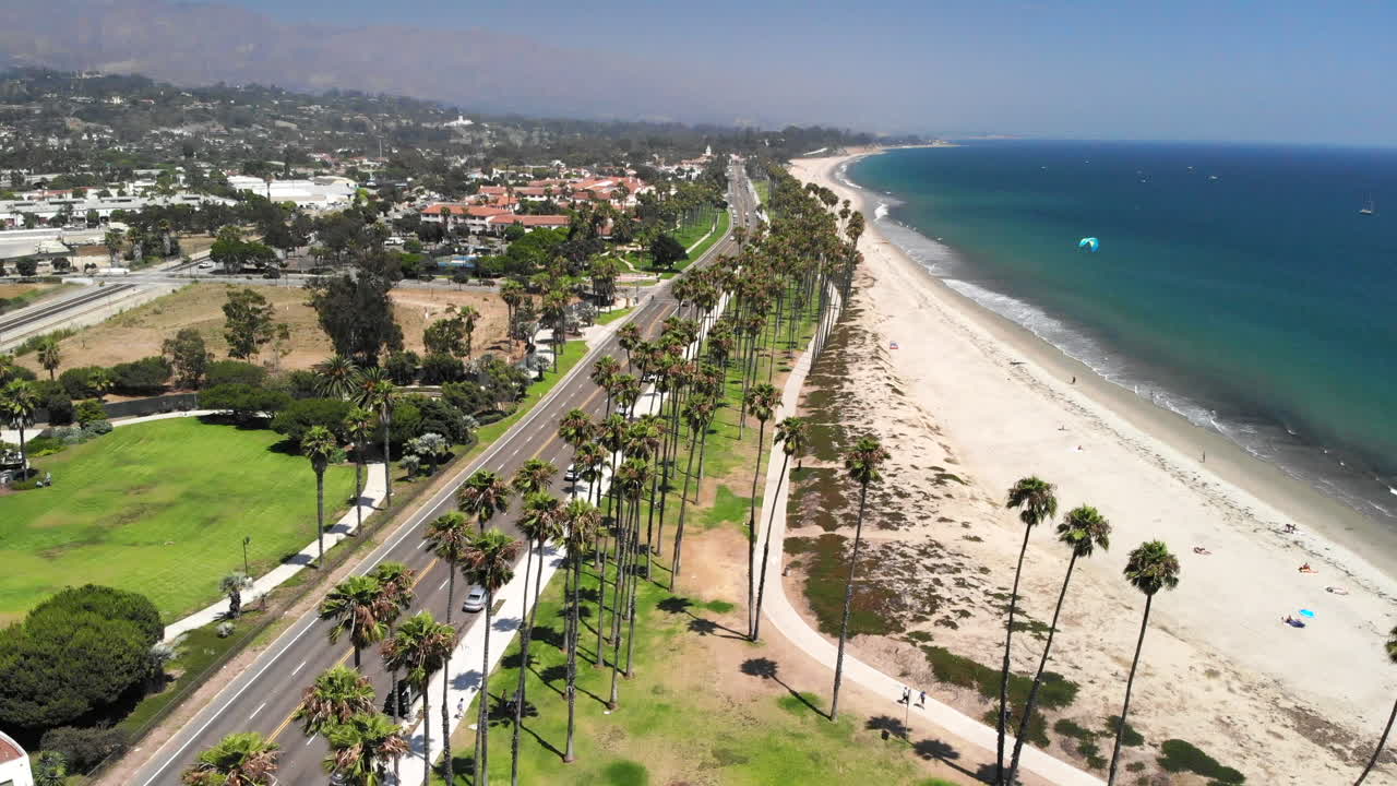 캘리포니아주 화창한 산타바바라에 있는 태평양의 체이스 팜 공원과 모래 해변의 야자수 위로 공중 촬영