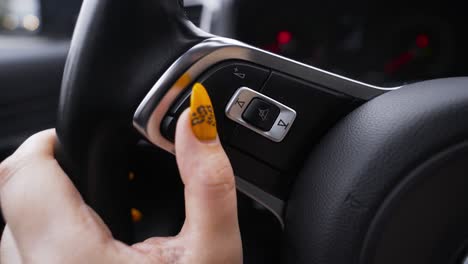 woman's hand operating car controls.