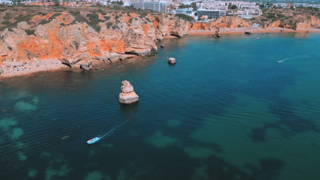 acantilados rocosos y un hermoso océano azul durante el verano en praia dona ana en el algarve en portugal, vista aérea de drones