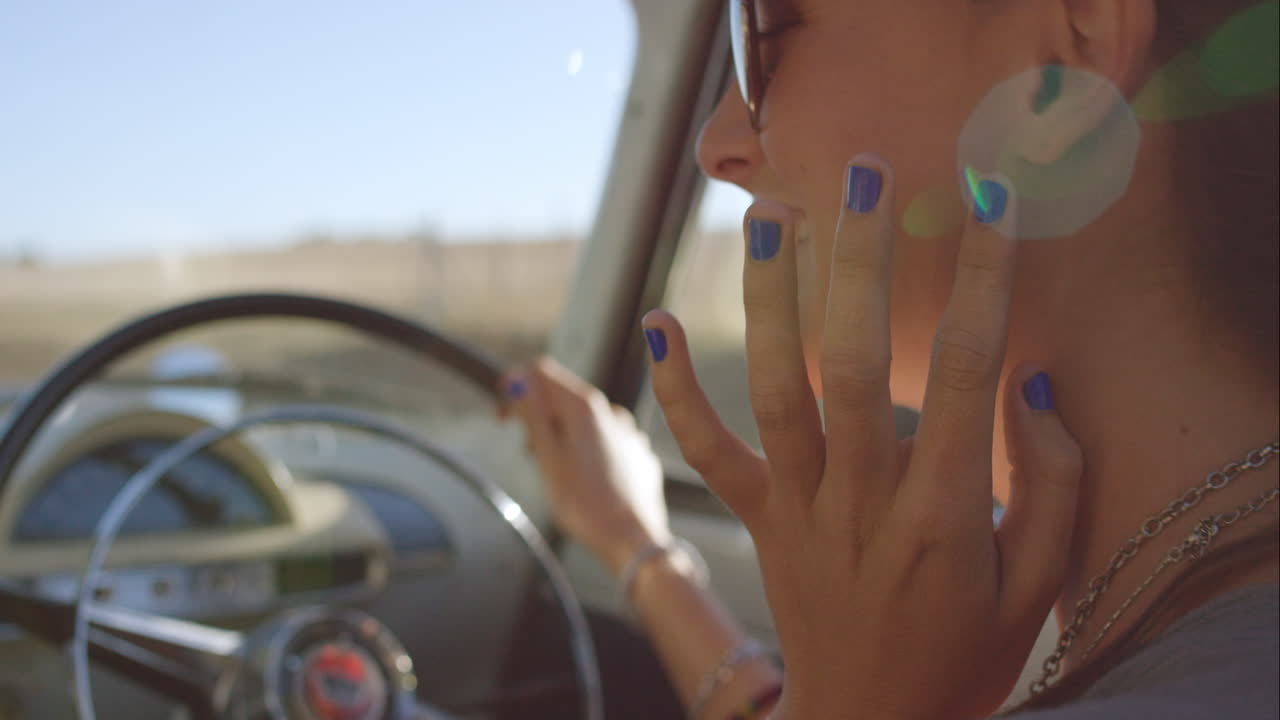 bella ragazza che guida un'auto d'epoca in un viaggio su strada