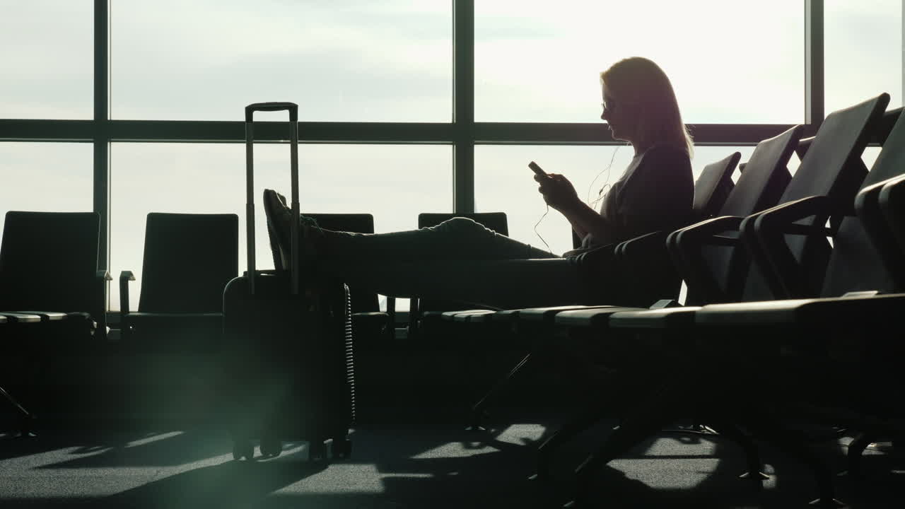 mujer en el aeropuerto usa un teléfono inteligente