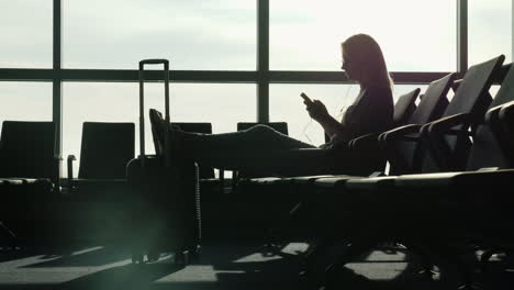 woman in airport uses a smartphone