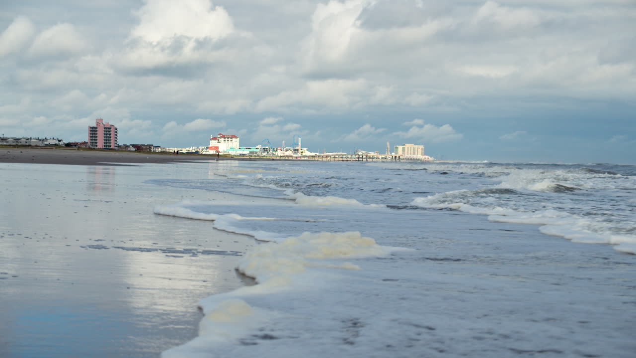 la marea se mueve en la costa de nueva jersey sobre el horizonte de ocean city en cámara lenta.