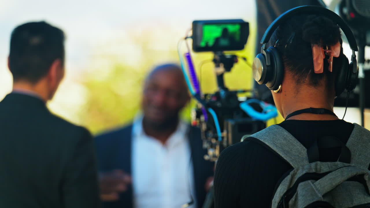 Videographers with professional equipment filming two men talking outside in Cannes, France