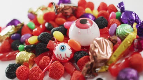 close up view of variety of halloween candies fallen against grey background