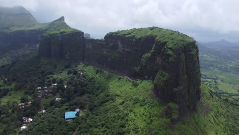 Aerial-view-of-the-scenic-landscape-of-Sahyadri-mountain-range-during-monsoon,-Brahmagiri-mountain-range-in-the-background,-Trimbakeshwar,-Nashik,-India