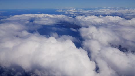 Eine-Luftaufnahme-Aus-Einem-Flugzeug-Fängt-Die-Weißen-Und-Flauschigen-Wolken-Während-Des-Hellen-Tages-Ein