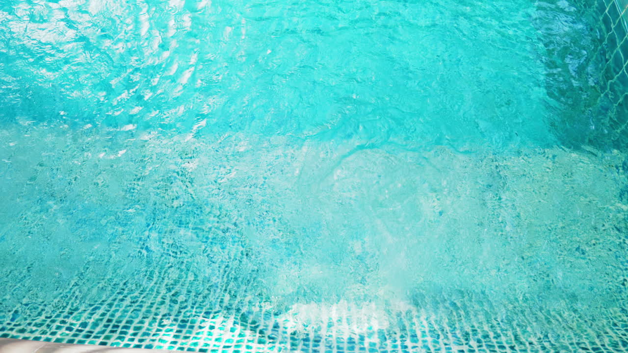 Una piscina con acqua in movimento e il fondo che rivela piastrelle e profondità.