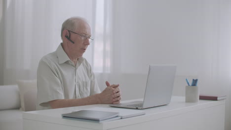 elderly-retiree-man-is-consulting-by-internet-with-specialist-speaking-and-gesticulating-looking-at-display-of-laptop