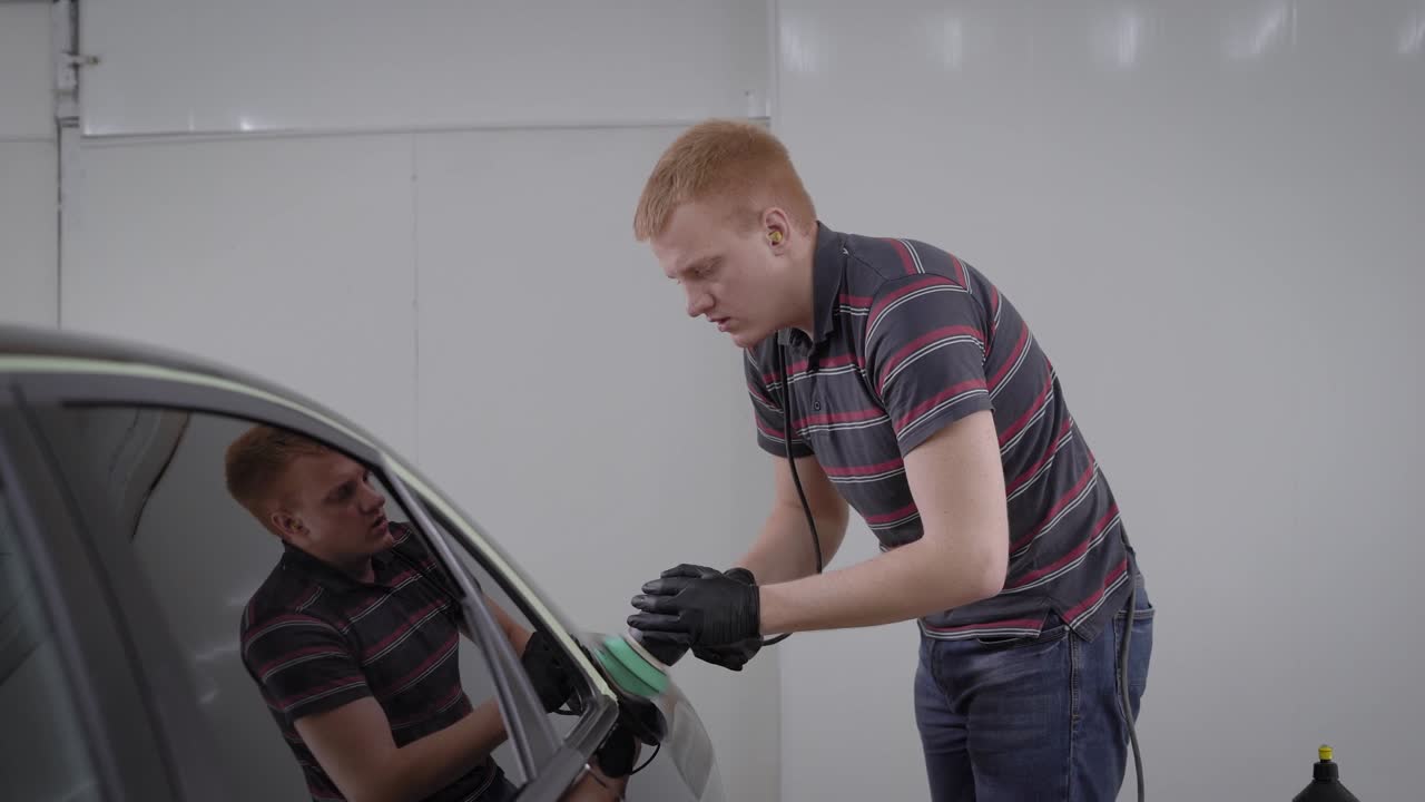 마스터는 자동차 서비스에서 빛나고 보호하는 표면에 검은 차의 염료를 부드럽게합니다.