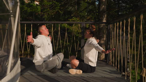 couple practicing yoga in a beautiful forest setting