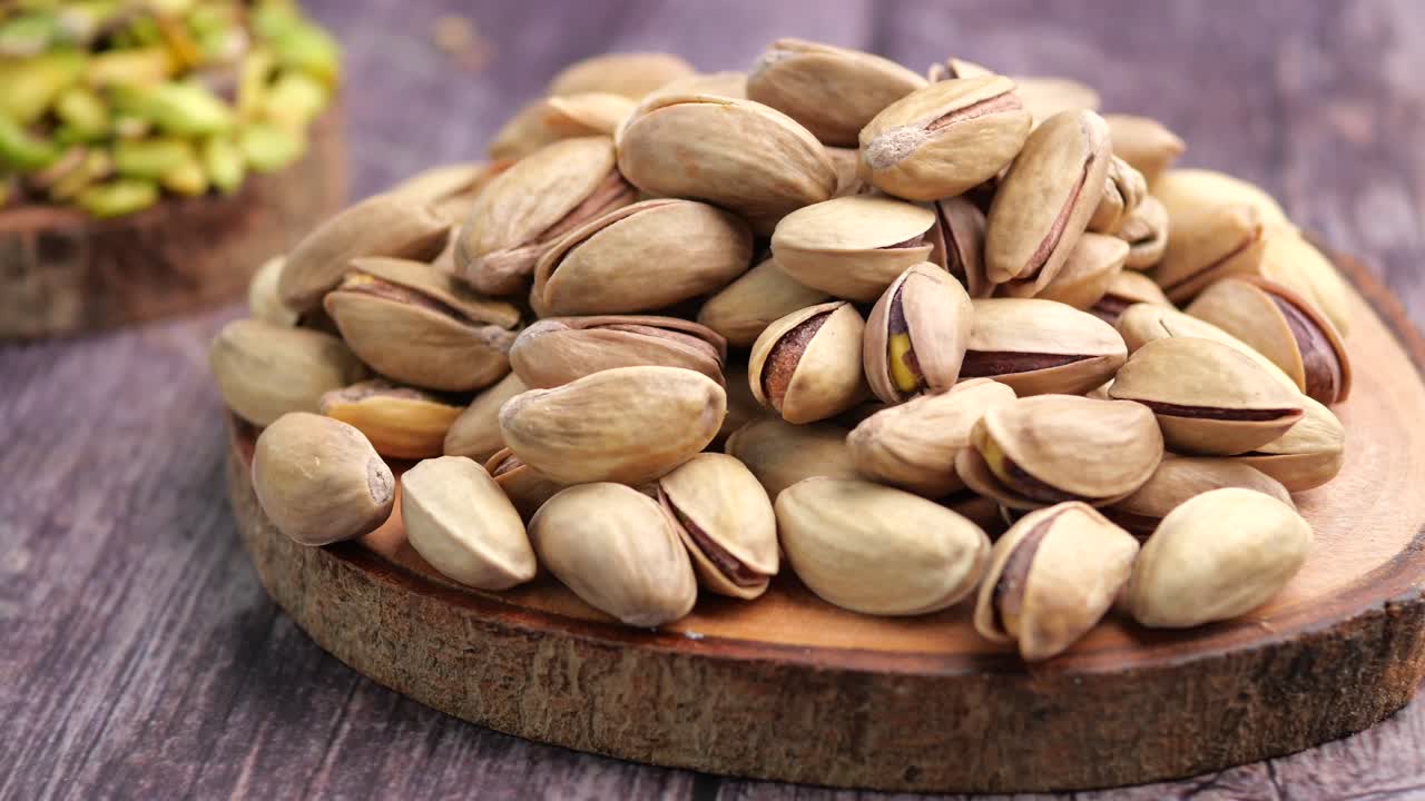 Pila di pistacchi su piatto di legno