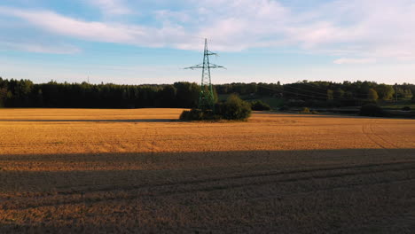 high power voltage cables stretch over agriculture field, aerial drone view