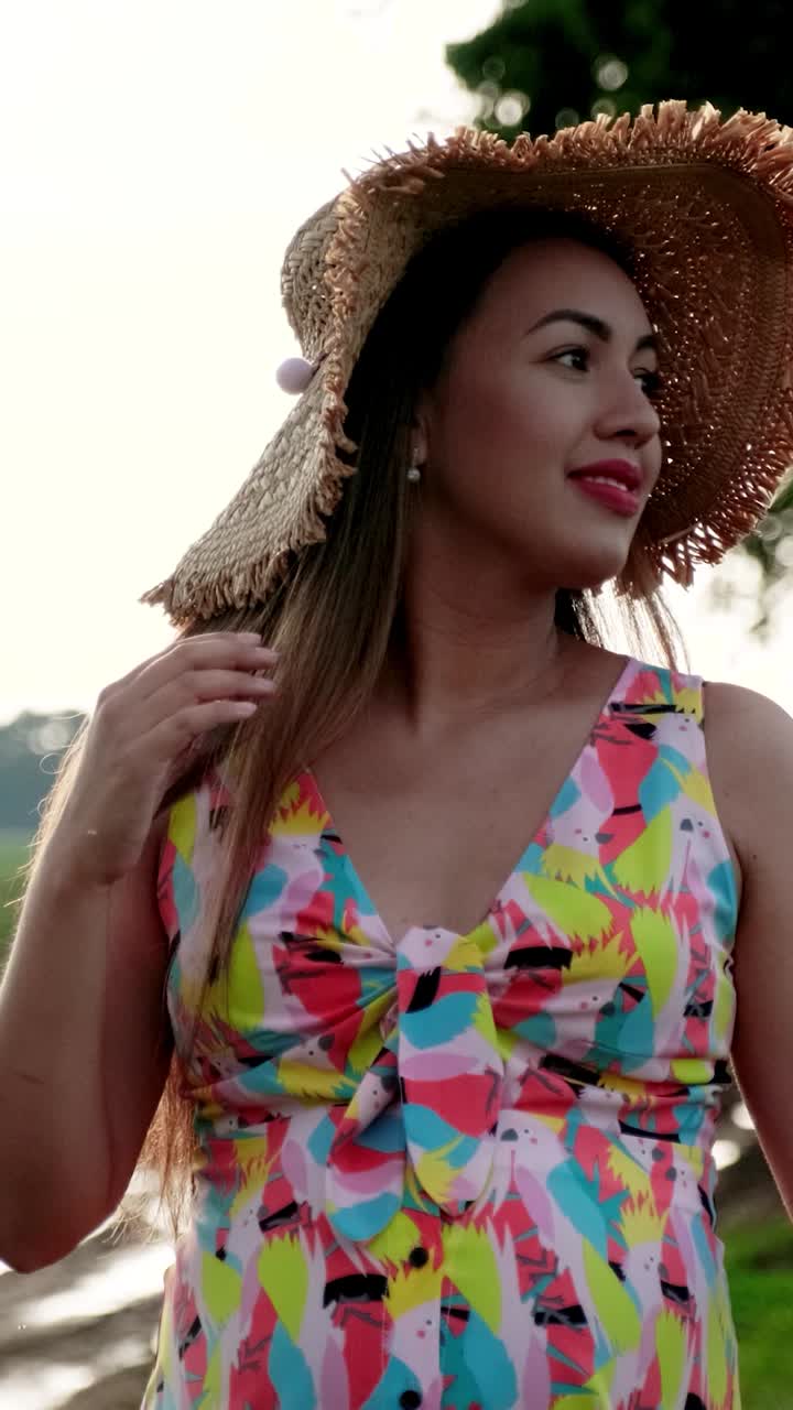 Woman in colorful dress and hat in a field