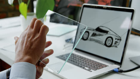 diseñador de coches usando una tableta digital de vidrio en la oficina 4k