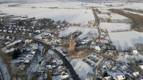 beautiful aerial of church standing in small rural town in winter
