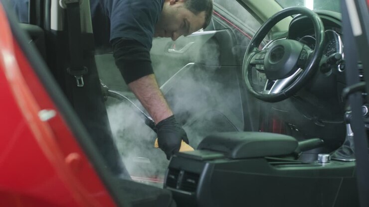 Professional car cleaning. Сar wash. Interior detailing. Dry clean and detail a car interior. Deep seats cleaning. Wiping foam in car wash. Cleaning the car panel from dust. A vacuum cleaner