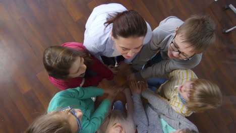 seis niños unidos de manos con el maestro