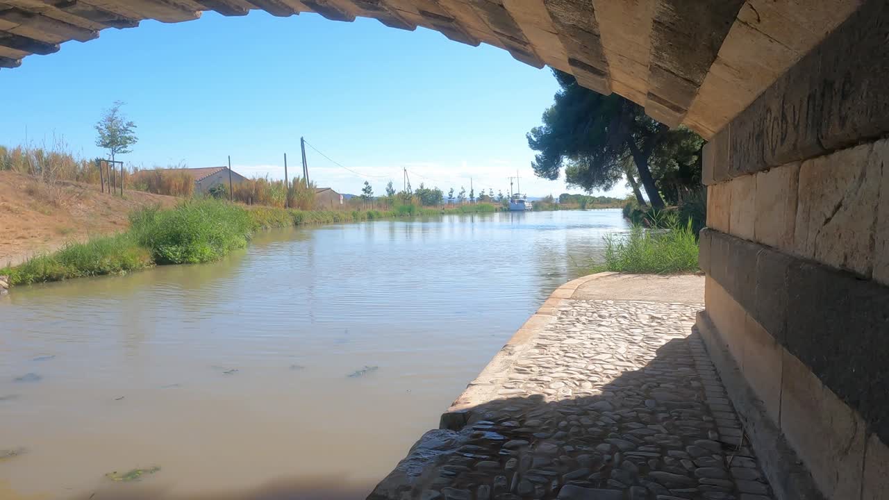 sendero de remolque bajo un puente en el canal du midi france en el pueblo de le somail